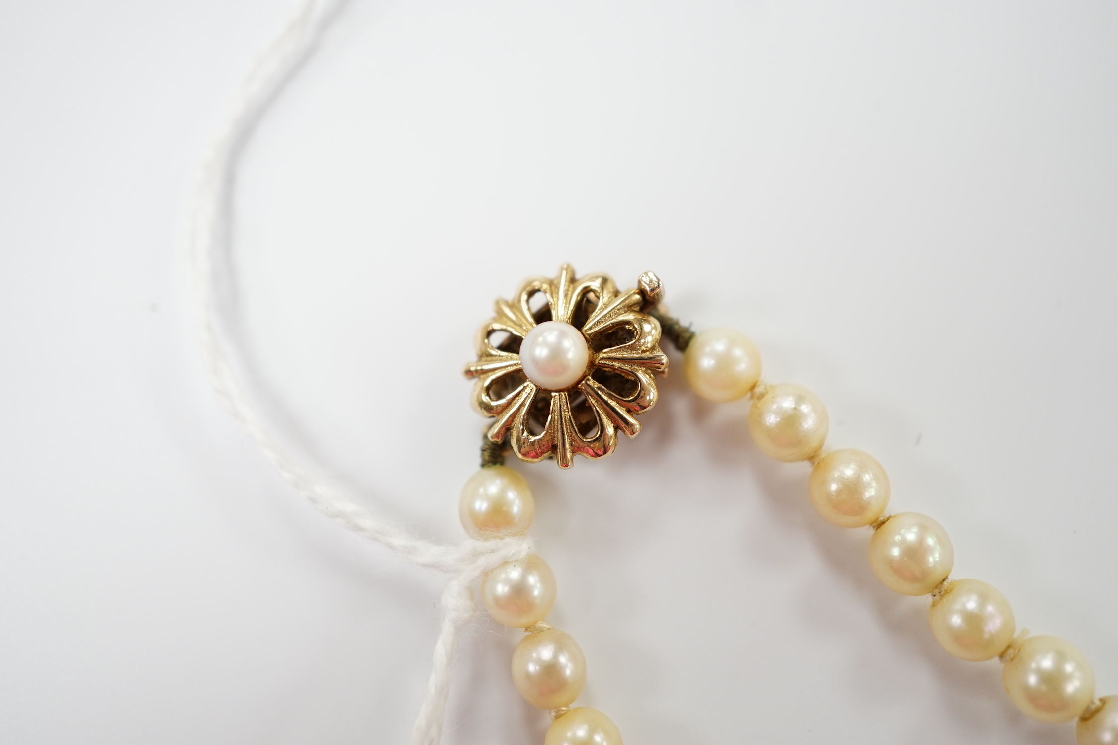 A single strand graduated cultured pearl necklace, with cultured pearl set yellow metal clasp, 42cm.